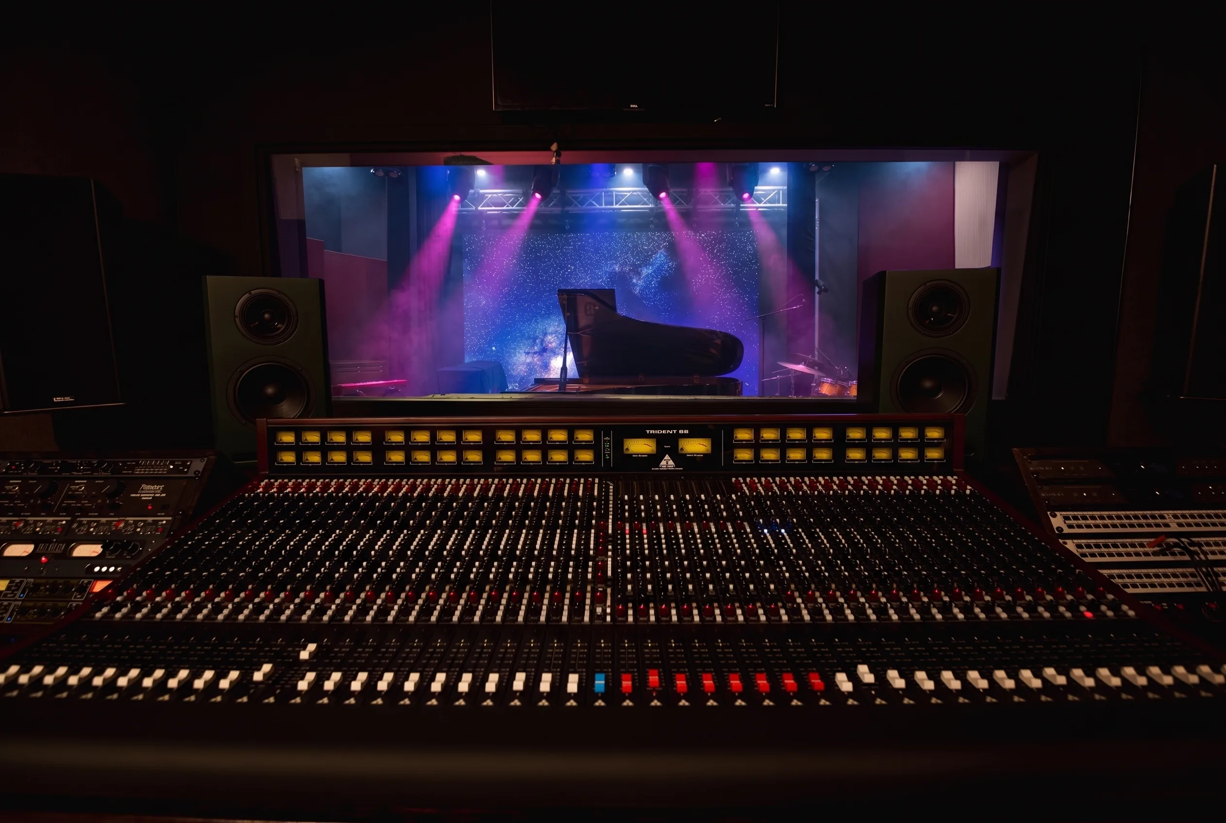 The live room seen through the control room glass behind the Trident console